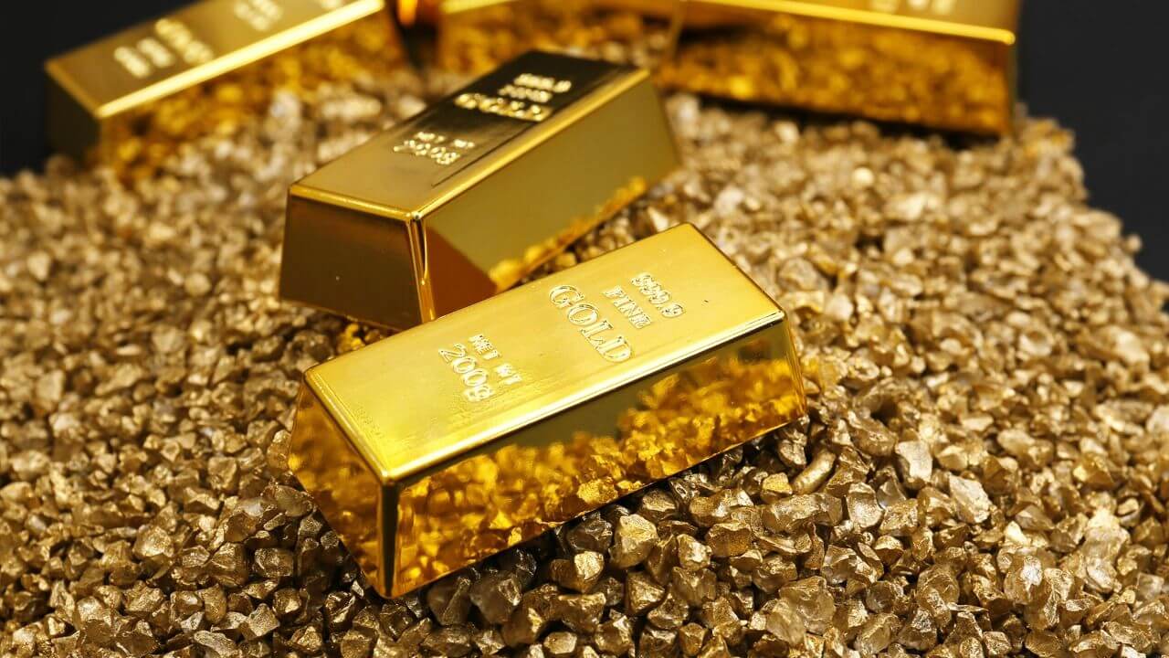 Gold bullion bars resting on gold granules